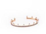 a gold bracelet with white diamonds and pearls