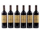 four bottles of wine are lined up on a white surface