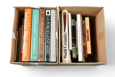 de nombreux livres dans une boîte posée sur une surface blanche