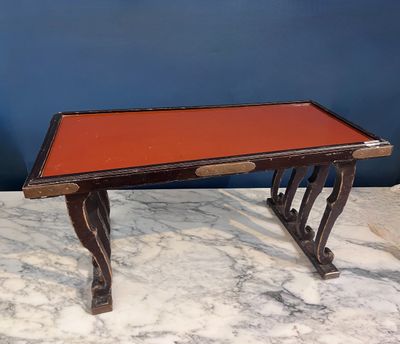 une image représentant une table au plateau rouge posée sur un socle en marbre