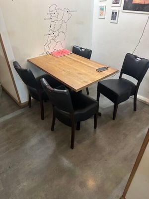 des tables et des chaises dans une petite pièce où est accroché un dessin au mur
