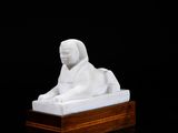 an image of a white statue of a lion on a wooden base