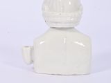 a small white vase sitting on a white surface