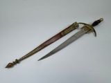 an old dagger is laying on a white surface next to a knife