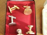 a box of cufflinks and a box of cufflinks on a table