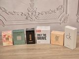five boxes of perfume sitting on a table next to each other