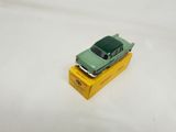 a green toy car sitting on top of a yellow box