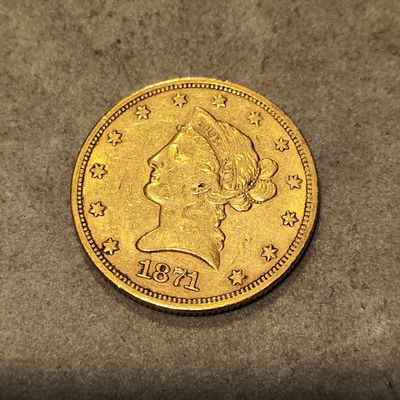 Gros plan sur une pièce d'or ornée d'une tête de femme