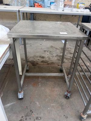 a table with a metal frame on wheels in a room