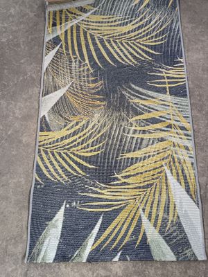 un gros plan d'un tapis orné d'un motif de feuilles de palmier