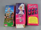 two boxes of barbie dolls are lined up on a table