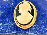 un gros plan sur le portrait d'une femme gravé sur un pendentif plaqué or