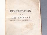 an old book sitting on top of a table next to a pair of scissors