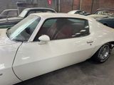 a white car parked in a garage with other cars in the background