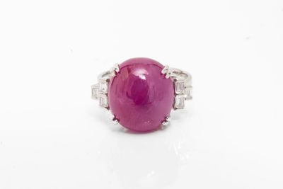 gros plan d'une bague en pierre rose sur une surface blanche