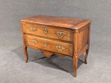 une petite commode en bois sur fond gris