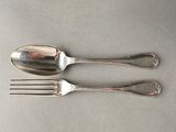 two silver spoons and a fork sitting on a table