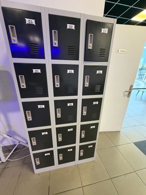 several black lockers are lined up in a room with tile flooring