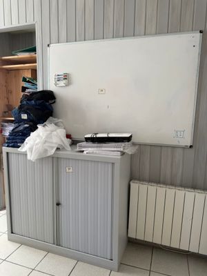 a white board on the wall next to a cabinet