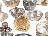 many different types of silverware on a white surface