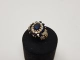 a gold ring with a blue stone surrounded by white diamonds