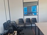 a room with a table, chairs, and boxes in it