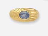 une image d'une bague en or avec une pierre bleue au centre