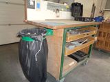 a trash can sitting next to a workbench in a garage