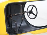 a close up of a small yellow car with a steering wheel