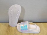 a close up of a pair of white sandals on a wooden table