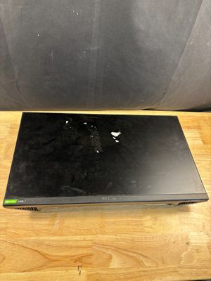 a black laptop on a wooden table with a black chair in the background