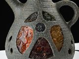a vase that has a lot of different colored stones in it