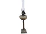 une lampe à huile à l'ancienne posée sur un socle, sur fond blanc