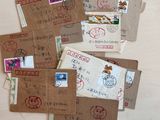 several envelopes with stamps are sitting on a table next to a pair of scissors