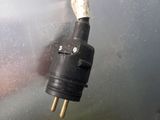 a close up of a black and gold plug on a metal surface