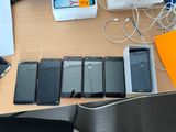 Plusieurs téléphones portables sont alignés sur une table à côté d'un ordinateur portable