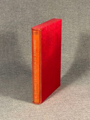 an orange book sitting on top of a table next to a gray wall