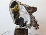 a glass table with a metal sculpture on top of it