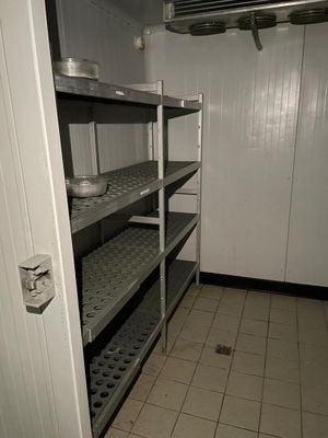 une pièce équipée d'étagères et d'une porte donnant sur une salle de bains