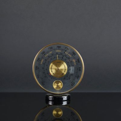 une horloge dorée et noire posée sur une table noire
