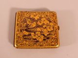 an image of a small gold box with a bird and flowers on it
