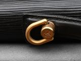 a close up of a black umbrella with a gold buckle