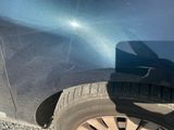 un gros plan sur le pneu avant d'une voiture qui a un trou