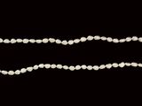 un gros plan d'un collier de perles blanches sur fond noir