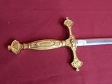 a gold and silver sword on a red cloth
