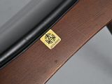 a wooden chair with a black seat and a yellow sticker on it