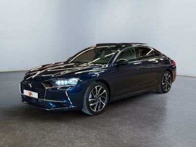 une voiture bleue garée dans une grande pièce aux murs blancs