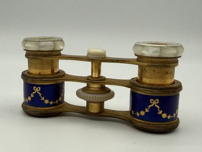 a gold and blue pair of binoculars on a white background