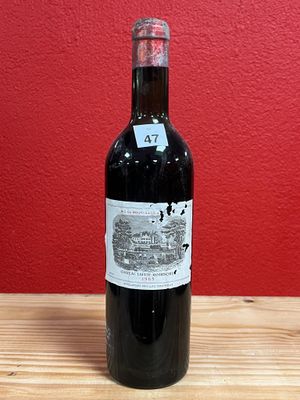 a bottle of red wine sitting on a wooden table