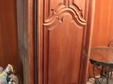 a wooden cabinet in the corner of a room next to a table